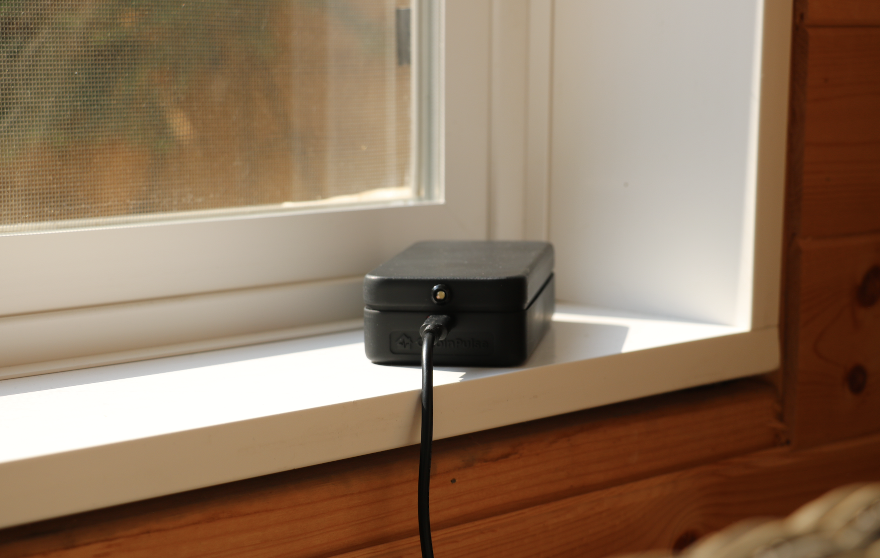 CabinPulse on a windowsill, monitoring for power outages in a remote cabin in Canada.